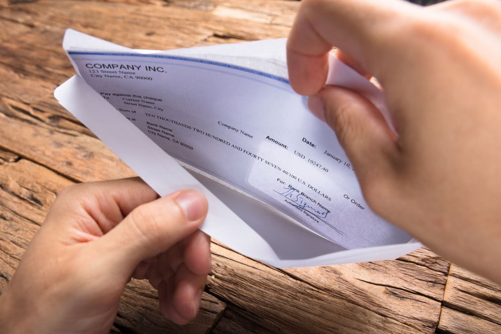 Man Opening Envelope With Check